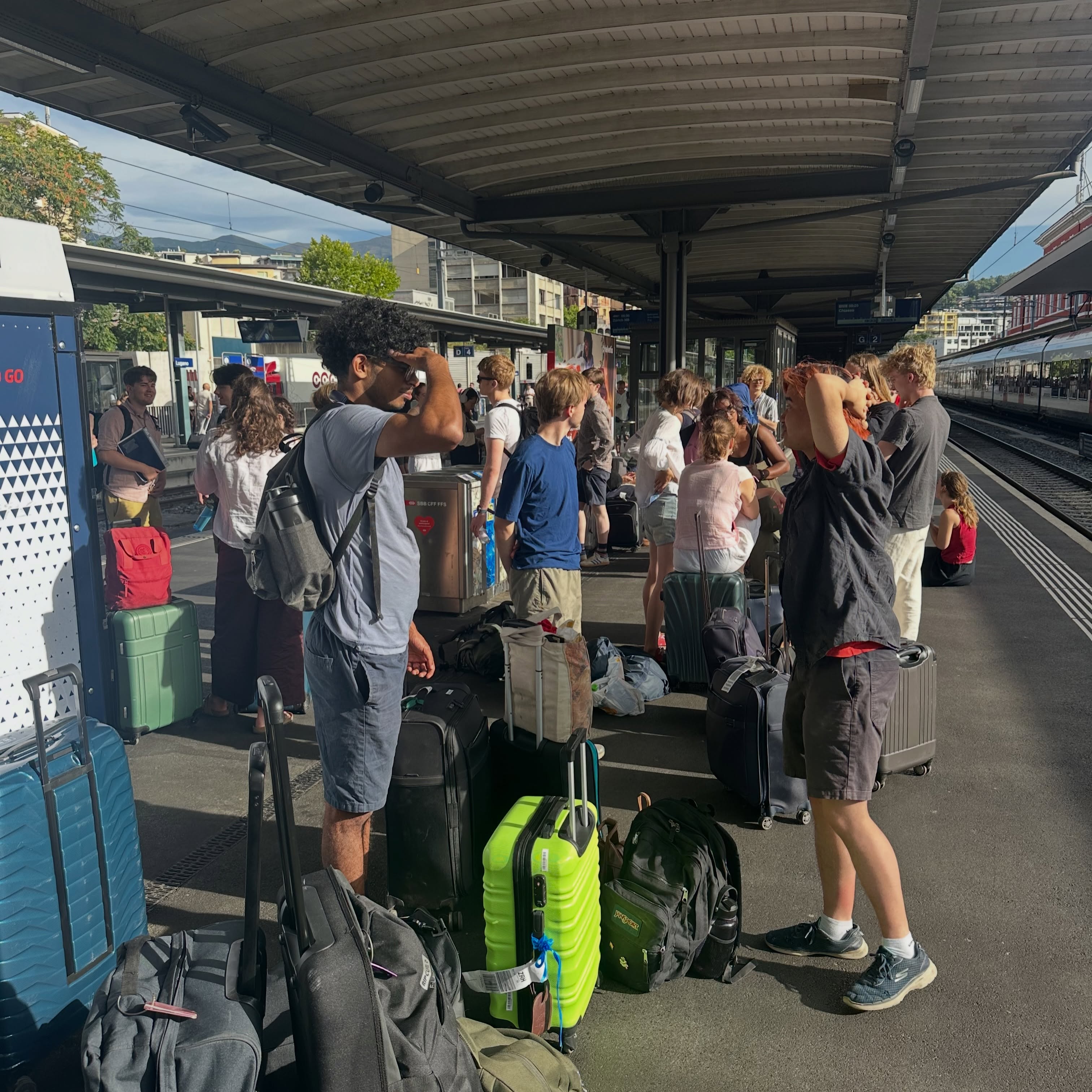 Switzerland / Italy Tour Blog Day 4:
The Clare Choir Clan arose early to depart from our wonderful hostel to go to Lugano station, where several trains passed us by in a game of “is this or is this not our train?” After having made it to Milan, there was a streamlined and seamless transition from one train to another. There, Sophia “get me on the DJ decks” Foster and Amelie “I make trap remixes for funerals” Huntley thus began the Grammy award-winning saga of mixing and mastering their remix of none other than Clare’s own Shepherds Pipe Carol, albeit with a few more beat drops and quantising of rhythmic cells than Rutter had originally intended, all of which was completed over the span of our 7 hour journey to Napoli. When they said that Clare College Choir required stamina, one might not have been aware of the physical efforts that this implied, with Choral Scholar Eoin “gym bro” Jenkins showing us how it’s done by hauling out our suitcases from the bus, the first stage of our total wipeout crash course speed run to the ferry, which was followed by a hell for leather sprint to the docks, dodging crazy busses and falling suitcases, between which Graham “race across Napoli” Ross put us all to shame by not even breaking a sweat and being able to video the entire chronicles of this experience … the footage of this has been purposefully lost. Ross’ review of Huntley and Foster’s magnum opus proved rewarding and may in fact be featuring on the next album for this physically tired College Choir. A dash to the supermarket was made before being bussed up the mountain to the site where the uttered music went missing, William Walton’s estate, where we enjoyed light snacks in celebration of health, wealth, and harmony. This choir’s physical training didn’t stop there as many laps of Walton’s wonderful water world swimming pool was made but completely (not) in silence, just as Daniel “no gaps” Livermore requested. This was my experience of the day.
Kathryn (Dec Sop)